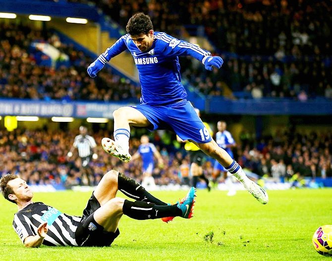 Diego Costa of Chelsea jumps over a challenge from Michael Williamson of Newcastle United 