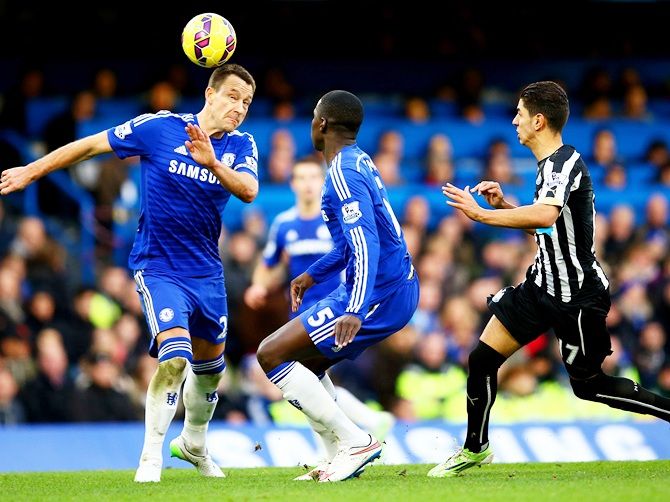 John Terry of Chelsea clears the ball under pressure from Ayoze Perez of Newcastle United