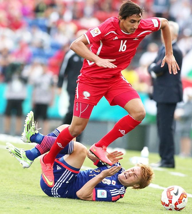 Mahmoud Dhadha of Palestine jumps over Gotoku Sakai of Japan 