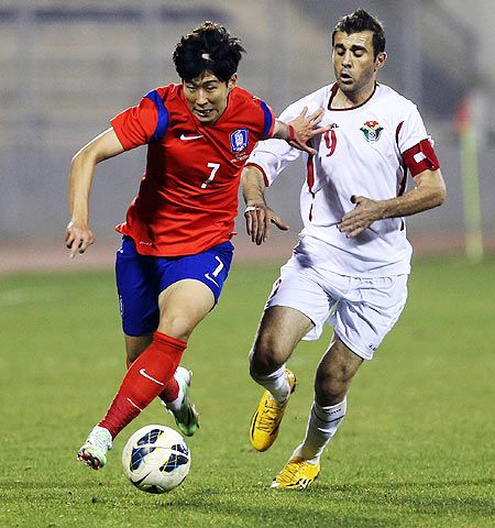 Ahmad Hayel of Jordan (right) vies for possession with Youngcheol Cho of South Korea