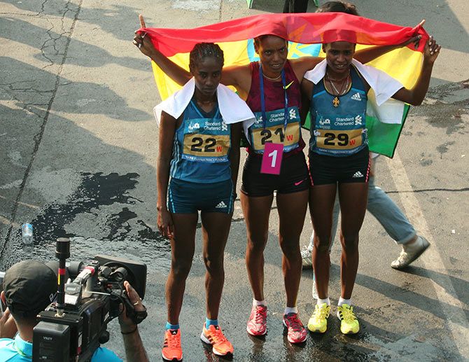 Ethiopians Dinknesh Mekash, Kumeshi Sichala and Marta Megra pose on the finish line on completing the Mumbai Marathon in the first three positions