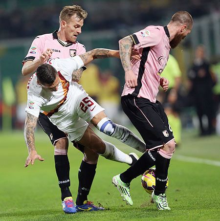 Palermo's Luca Rigoni (left) and Michael Morganella compete for the ball with Roma's Jose Hobales during their Serie A match at Stadio Renzo Barbera in Palermo on Saturday