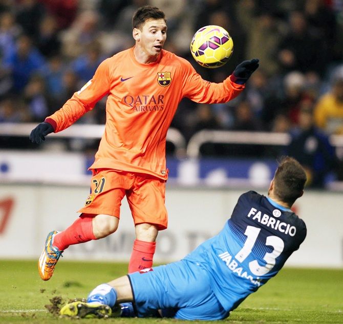 Barcelona's Lionel Messi, left, scores a goal in front Deportivo de la Coruna's goalkeeper Fabricio