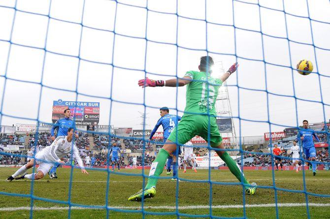 Cristiano Ronaldo of Real Madrid heads the ball past Jordi Codina of Getafe CF