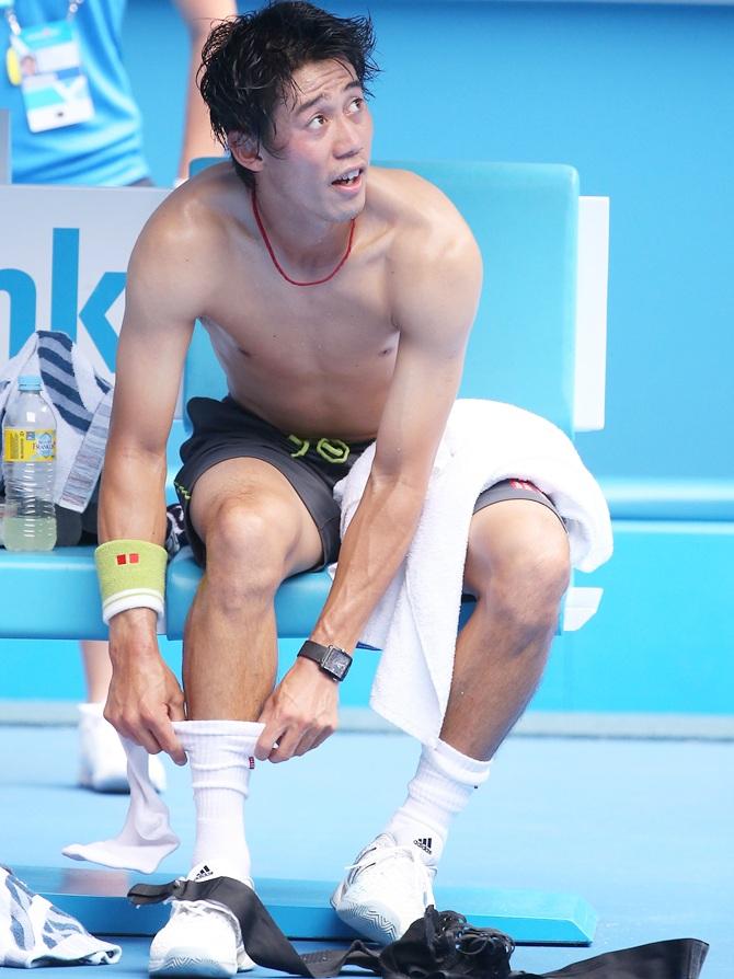 Kei Nishikori of Japan changes shirt