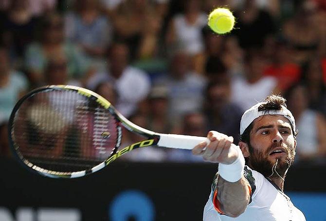 Simone Bolelli of Italy hits a return to Roger Federer of Switzerland 