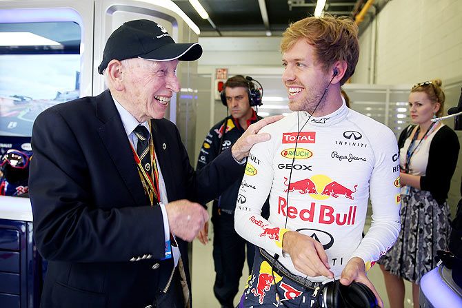 Sebastian Vettel speaks with John Surtees in the team garage