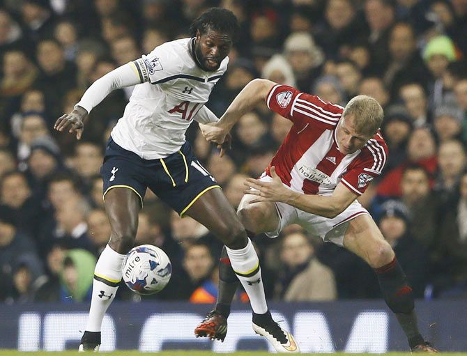 Sheffield United's Jay McEveley challenges Tottenham Hotspur's Emmanuel Adebayor (left)