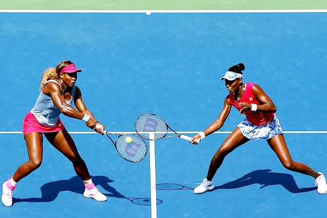 Venus Williams, right, and Serena Williams of the United States return a shot