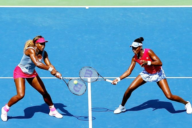 Venus Williams, right, and Serena Williams of the United States return a shot