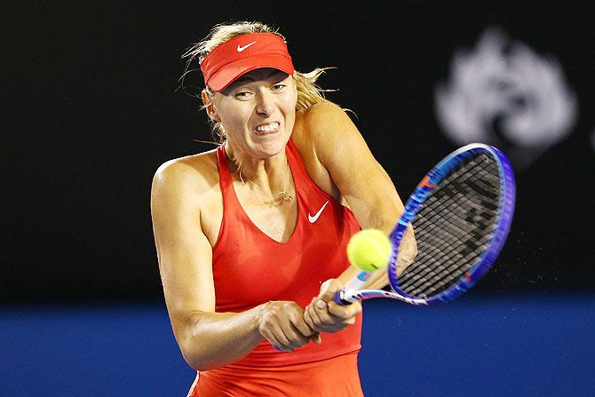 Maria Sharapova plays a backhand against Serena Williams