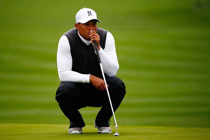 Tiger Woods assesses a putt on the 17th green