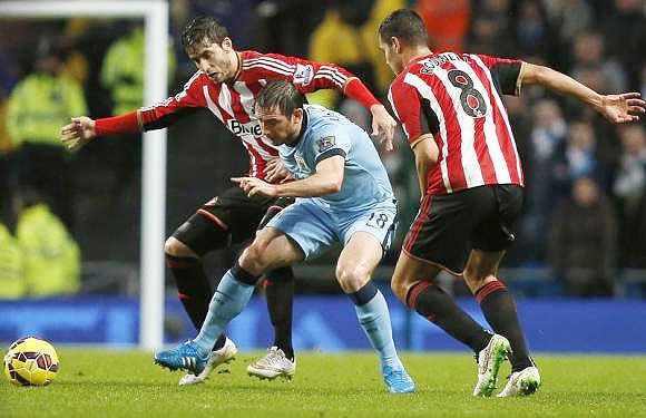 Manchester City's Frank Lampard (centre) is challenged by Sunderland's Ricardo Alvarez (left) and Jack Rodwell during their English Premier League match at the Etihad Stadium in Manchester on Thursday