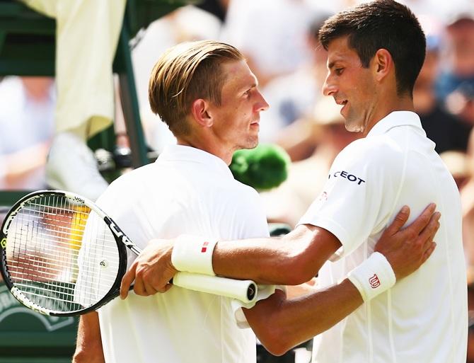 Jarkko Nieminen of Finland (L) congratulates Novak Djokovic