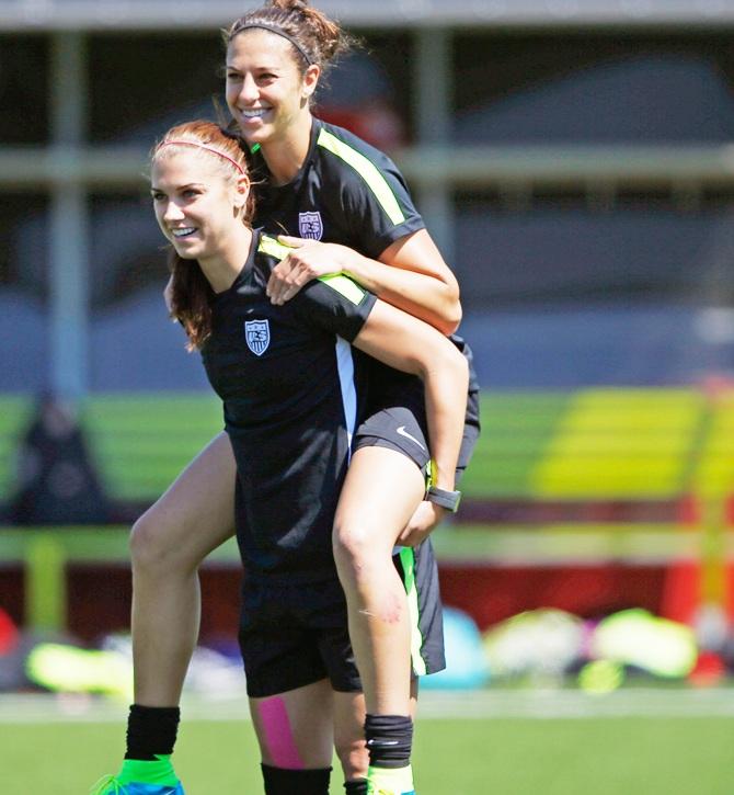 USA's forward Alex Morgan carries midfielder Carli Lloyd