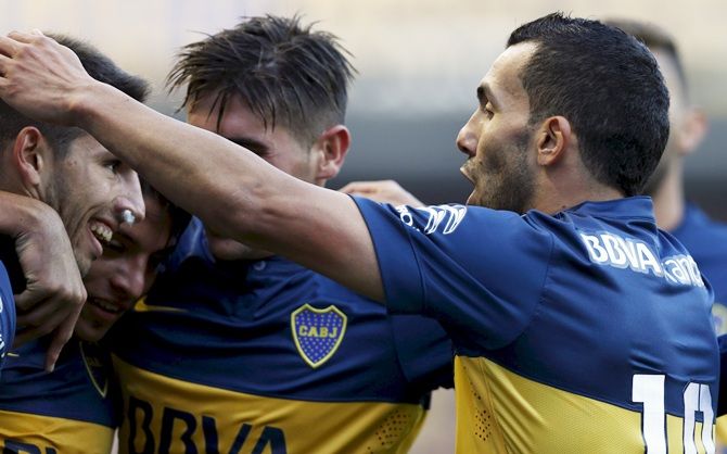 Boca Juniors' Carlos Tevez, right, embraces teammates