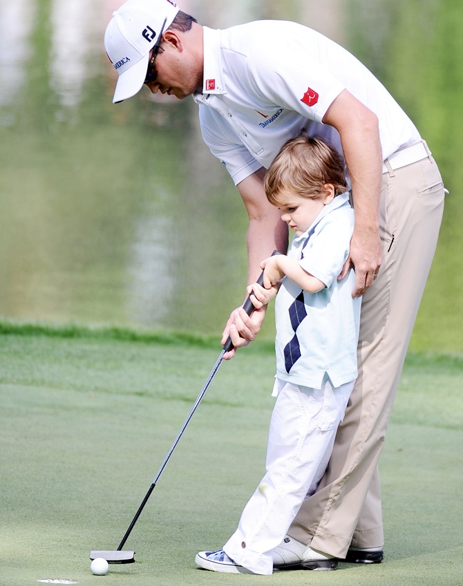 Zach Johnson putts with his son