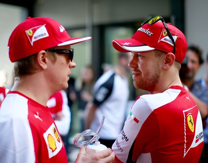Sebastian Vettel speaks with Kimi Raikkonen 
