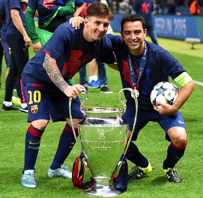 FC Barcelona’s Lionel Messi and Xavi Hernandez celebrate with the trophy after winning the UEFA Champions League final against Juventus at Olympic Stadium in Berlin on June 6