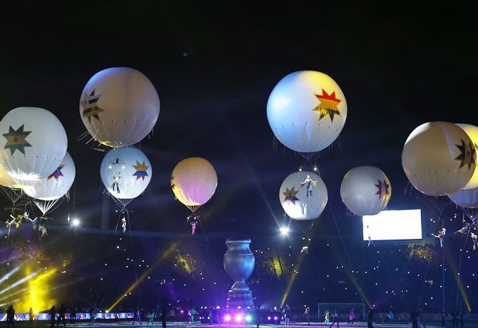 Performers dangling from balloons rise into the air during the Opening Ceremony 