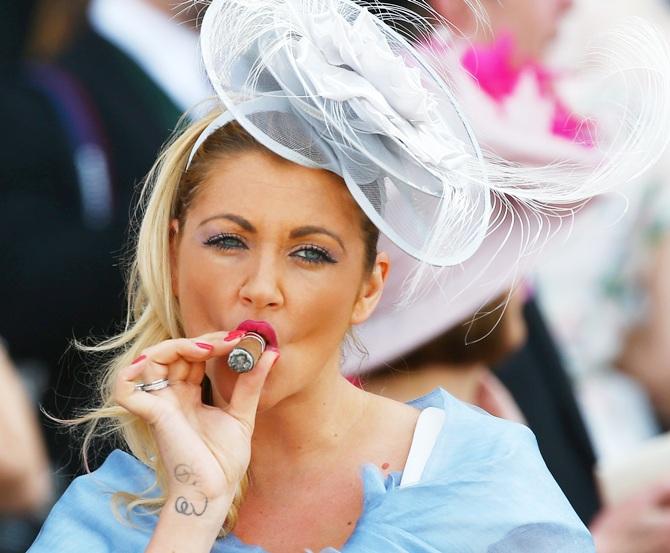 A race goer enjoys a cigar