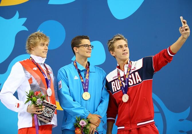 From left, silver medalist Pawel Sendyk of Poland, gold medalist Andril Khloptsov of Ukraine and bronze medalist Daniil Pakhomov of Russia pose with the medals won during the Men's 50m Butterfly final