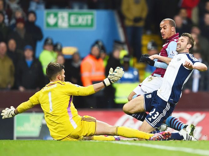 Gabriel Agbonlahor of Aston Villa scores the opening goal under pressure from Gareth McAuley and Ben Foster of West Brom