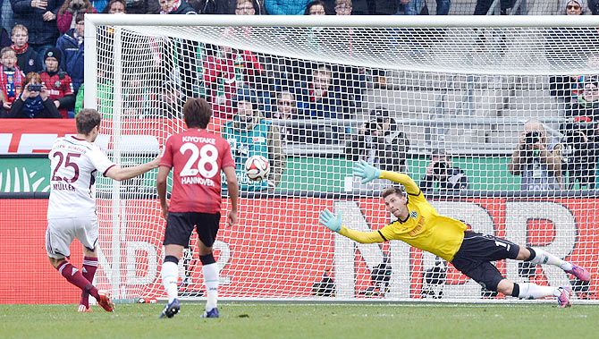 Bayern Munich's Thomas Mueller (left) scores a penalty against Hannover 96's goalkeeper Ron-Robert Zieler (right) during their Bundesliga first division match in Hanover on Saturday