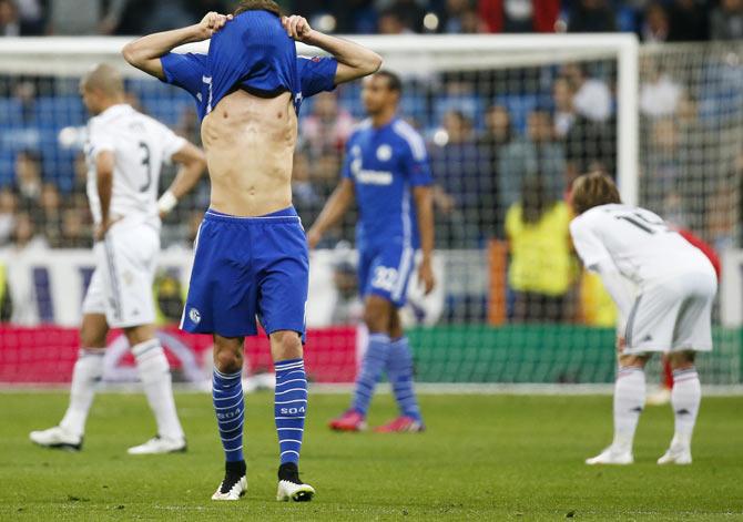 Schalke 04's Leon Goretzka covers his face with his jersey after they losing their round of 16 second leg soccer match against Real Madrid