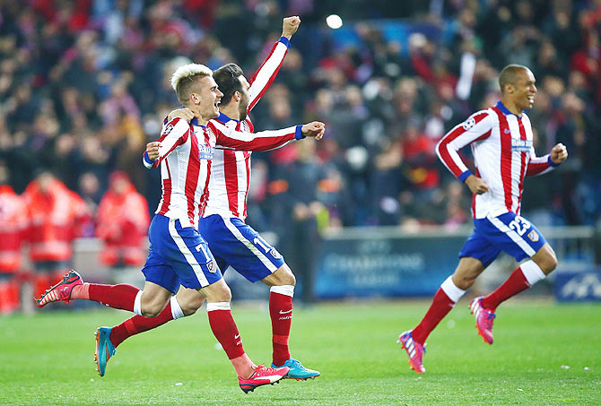 Antoine Griezmann and Jesus Gamez of Atletico Madrid celebrate after winning the penalty shootout against Bayer 04 Leverkusen at Vicente Calderon Stadium in Madrid
