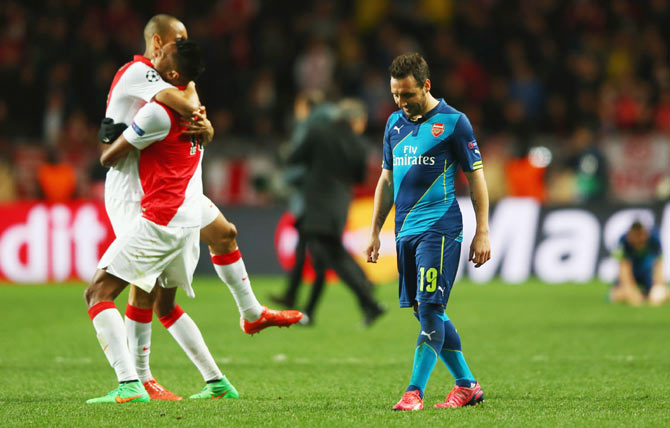 Arsenal's Santi Cazorla (right) looks dejected as Monaco players celebrate after qualifying for the quarter-finals of the Champions League Round of 16 second leg match at Stade Louis II in Monaco on Tuesday