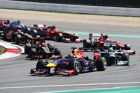Sebastian Vettel of Germany and Infiniti Red Bull Racing leads the field into the first corner at the start of the German Grand Prix at the Nuerburgring