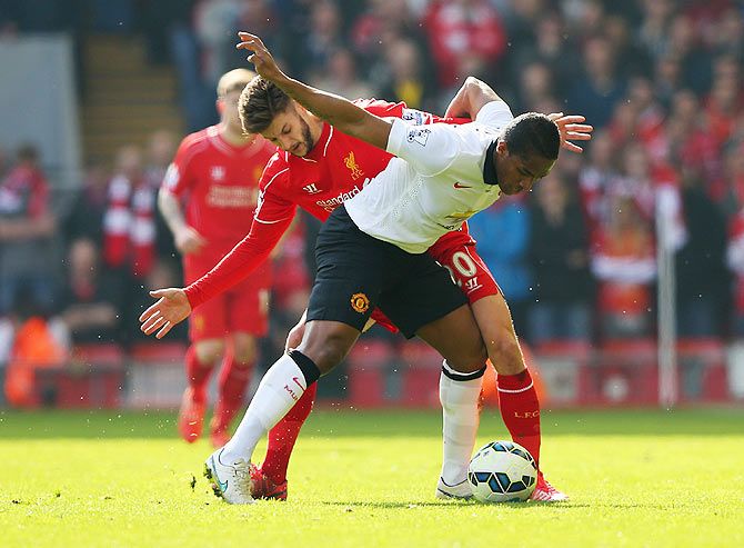 Manchester United's Antonio Valencia gets into a tangle with Liverpool's Adam Lallana as they vie for possession