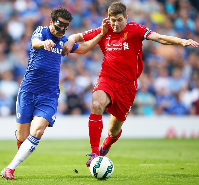 Cesc Fabregas of Chelsea and Steven Gerrard of Liverpool compete