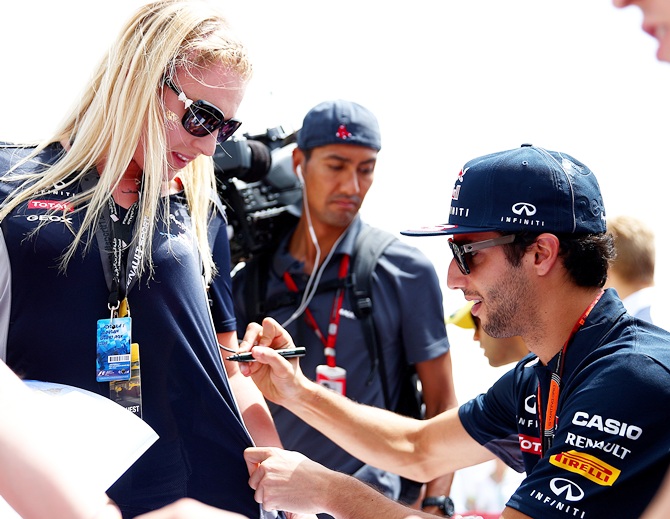 Daniel Ricciardo of Australia and Infiniti Red Bull Racing signs autographs for fans
