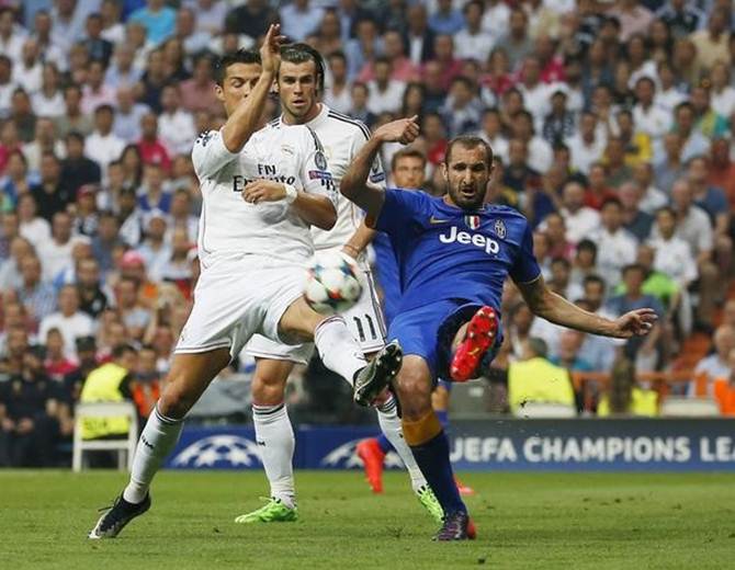 > Juventus's Giorgio Chiellini battles for possession with Real Madrid’s Cristiano Ronaldo as Gareth Bale looks on