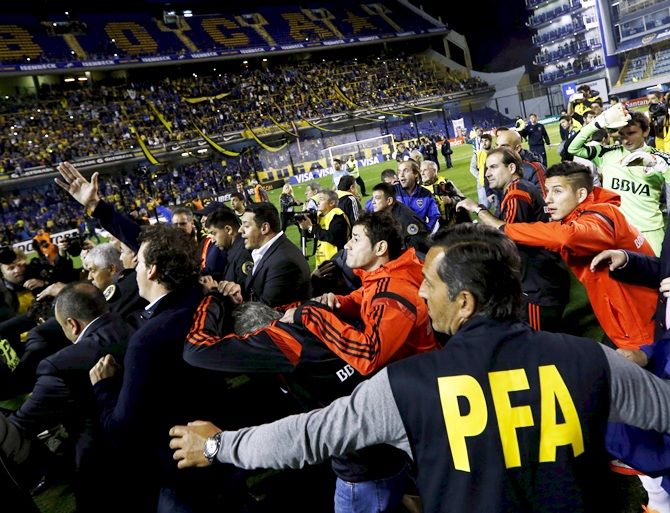 River Plate's players (in red) try to take cover as they leave after their Copa Libertadores match