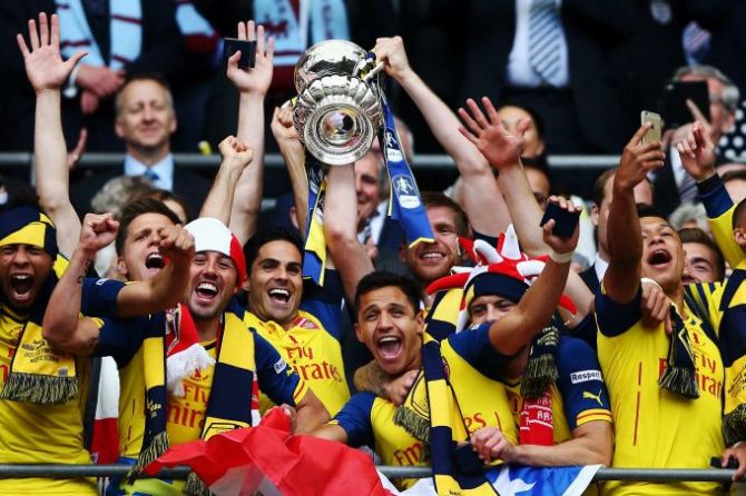 Per Mertesacker and Mikel Arteta of Arsenal lift the trophy