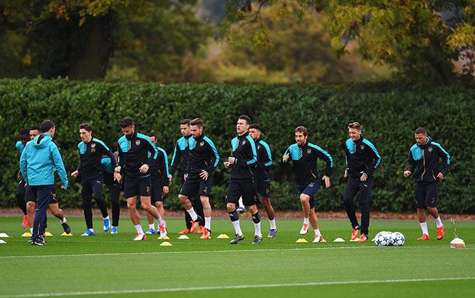 Arsenal players warm up during a training session ahead of the UEFA Champions League match against Bayern Munich 