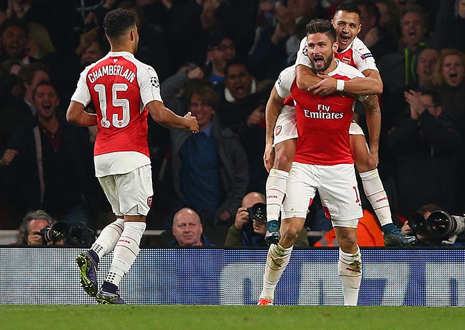 Olivier Giroud of Arsenal (center) celebrates with Alex Oxlade-Chamberlain (15) and Alexis Sanchez 