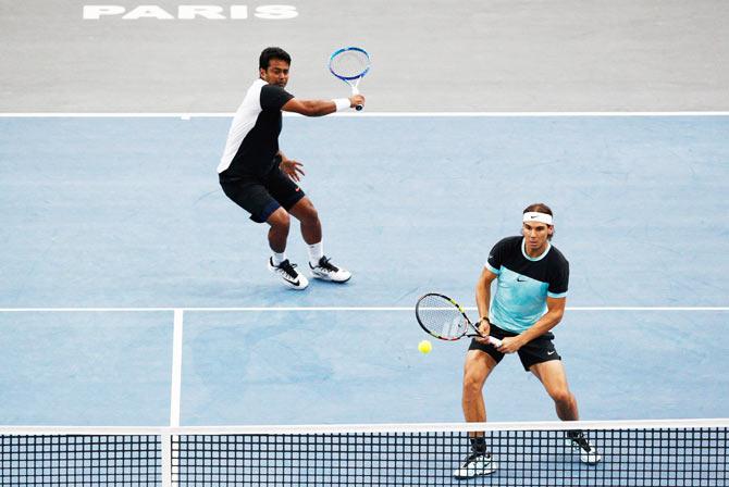 Spain's Rafael Nadal (right) and India's Leander Paes play a return against Great Britain's Dominic Inglot and Sweden's Robert Lindstedt during the Paris Masters 1st round match held at AccorHotels Arena in Paris on Tuesday