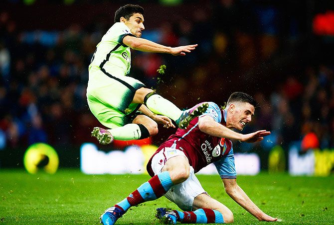 Manchester City's Jesus Navas is tackled by Aston Villa's Ciaran Clark during the Barclays Premier League match at Villa Park in Birmingham on Sunday