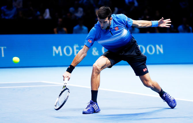 Novak Djokovic plays a backhand in his men's singles match against Roger Federer