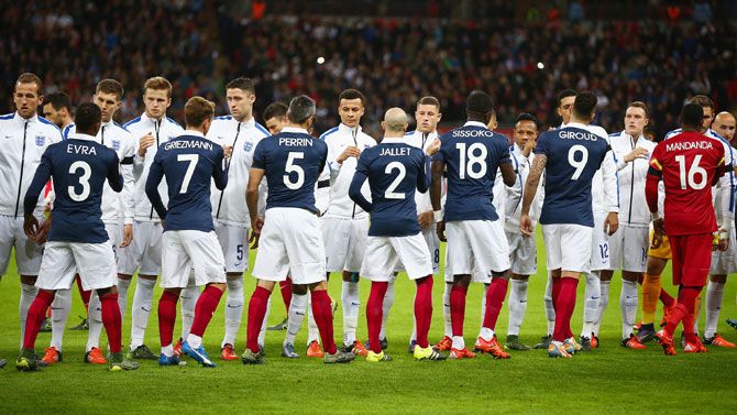French and English players greet each other prior to their international friendly at Wembley Stadium in London on Tuesday