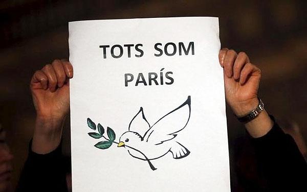 A woman shows a sign that reads 'We are Paris' in remembrance of the victims of the Paris attacks at Sant Jaume square in Barcelona on November 16