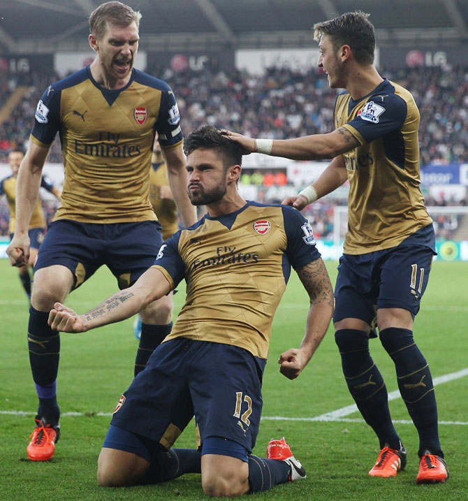 Arsenal's Olivier Giroud (centre) celebrates a goal with teammates Per Mertesacker (left) and Mesut Ozil