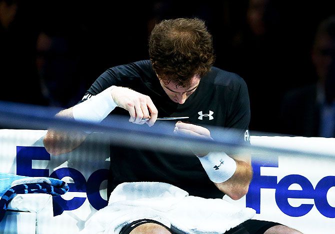 Great Britain's Andy Murray cuts his hair in-between games in his men's singles match against Spain's Rafael Nadal during the ATP World Tour Finals round robin match at the O2 Arena in London on Wednesday