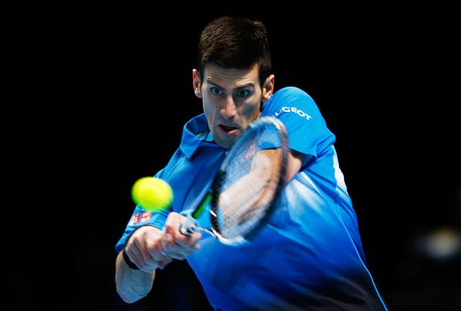 Novak Djokovic plays a backhand against Roger Federer