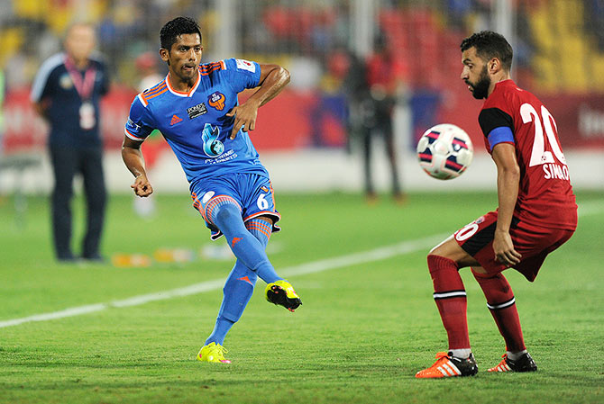 Raju Gaikwad of FC Goa tries to get the ball past Simao Sabrosa of NorthEast United FC 