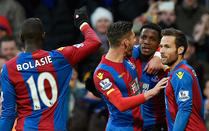 Wilfried Zaha celebrates with team mates after scoring the third goal for Crystal Palace 